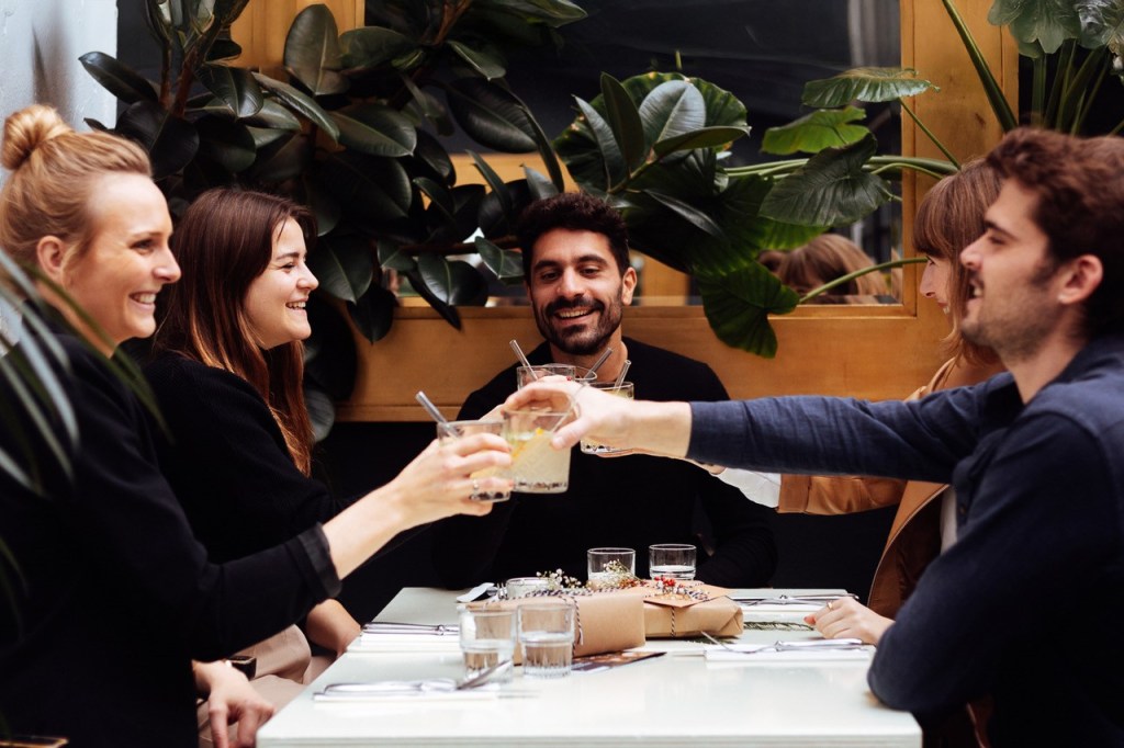 Freunde am Tisch stoßen an