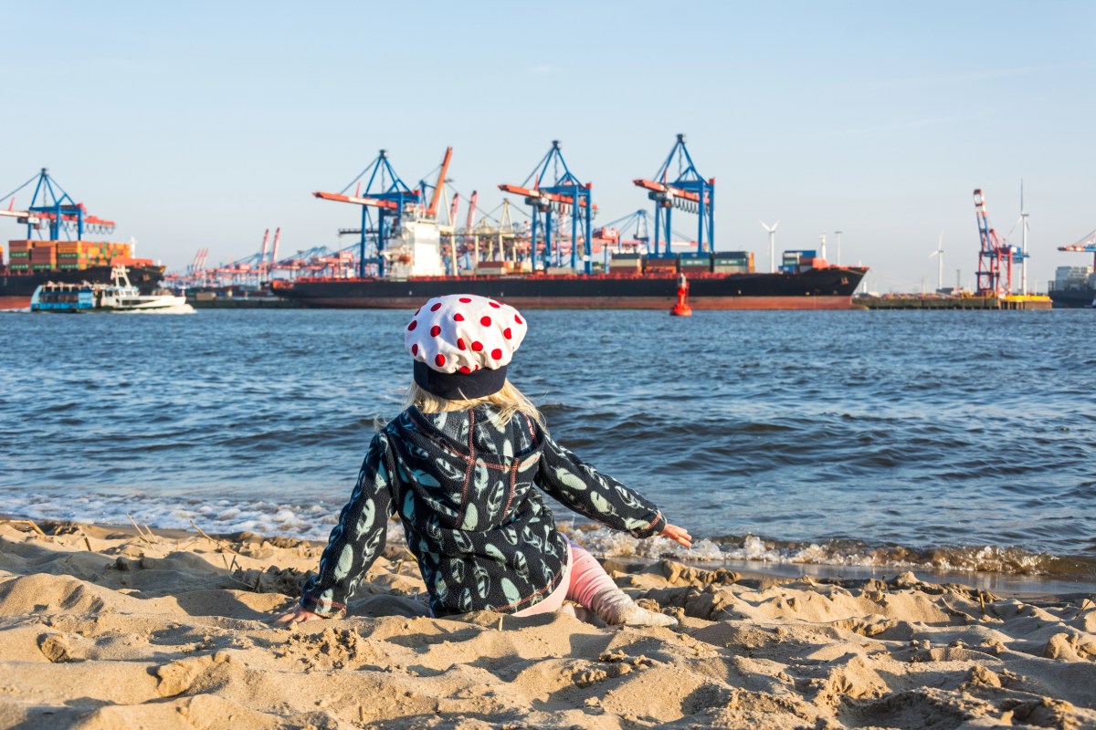 Kind am Strand vor Hafen