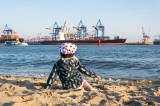 Kind am Strand vor Hafen