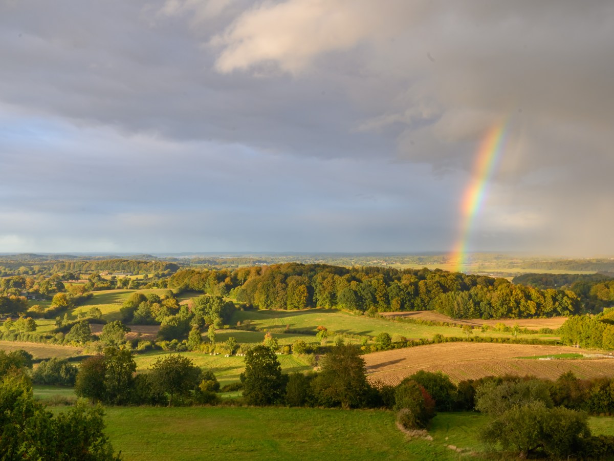 Regenbogen hinter malerischer Naturlandschaft