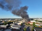 Rauchwolke über Hamburg, eine Lagerhalle steht in Flammen.